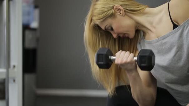 The girl performs a weightlifting exercise
